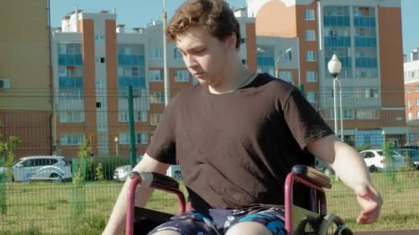 Άτομα με ειδικές ανάγκες ο άνθρωπος παίζει μπάσκετ από την αναπηρική καρέκλα του, στον ανοιχτό αέρα — Αρχείο Βίντεο
