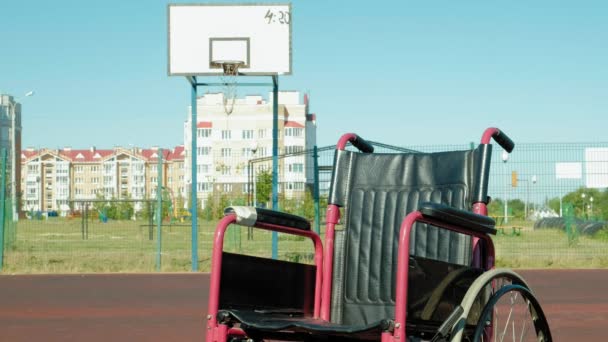 Art des Rollstuhls mit einem Basketballkorb auf einem Sportvolleyballfeld — Stockvideo