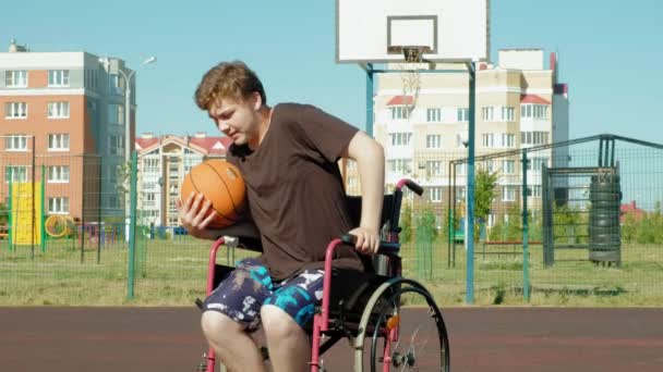 Homme handicapé joue au basket-ball de son fauteuil roulant, En plein air, Faire un effort en jouant — Video