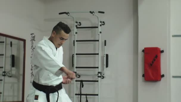 Молодой человек с мускулистым телом, тренирующий боевые искусства Годжу-рю каратэ-до — стоковое видео