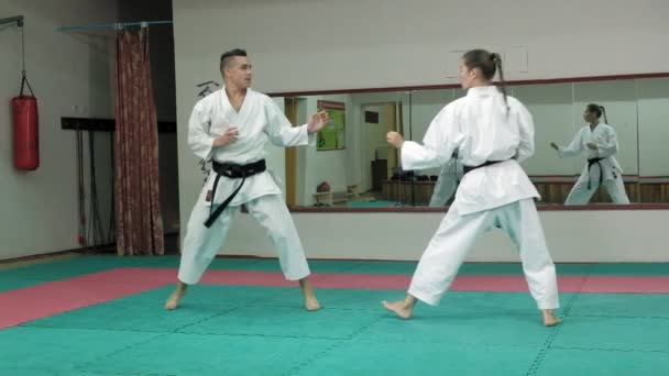 Un joven con un cuerpo musculoso y una mujer practicando artes marciales Goju-Ryu Karate-Do super cámara lenta — Vídeos de Stock