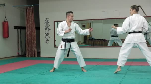 Un giovane uomo con un corpo muscoloso e una donna che pratica arti marziali Goju-Ryu Karate-Do super slow motion — Video Stock