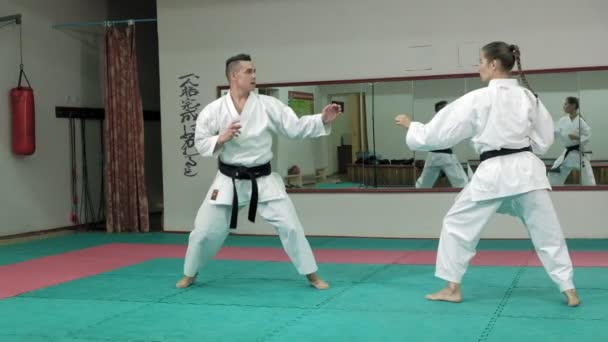 A young man with a muscular body and a woman practicing martial arts Goju-Ryu Karate-Do super slow motion — Stock Video