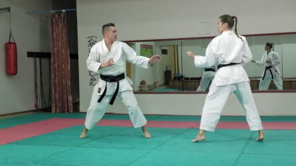 Egy fiatal ember, izmos test, és egy nő gyakorló harcművészetek Goju-Ryu Karate-Do szuper lassú mozgás — Stock videók