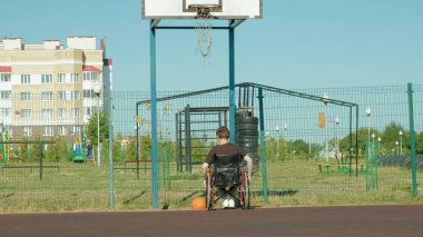 Engelli adam açık havada onun tekerlekli sandalye, basketbol oynuyor