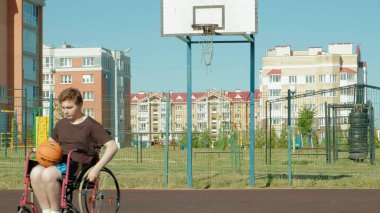 Engelli adam açık havada onun tekerlekli sandalye, basketbol oynuyor