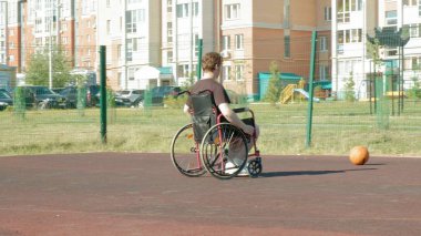 Engelli adam açık havada onun tekerlekli sandalye, basketbol oynuyor