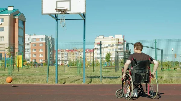Disabled man plays basketball from his wheelchair, On open air — Stock Photo, Image