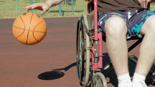 El hombre discapacitado juega baloncesto desde su silla de ruedas, al aire libre —  Fotos de Stock