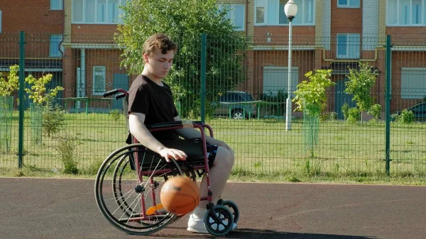 Behinderter spielt Basketball im Rollstuhl unter freiem Himmel — Stockfoto