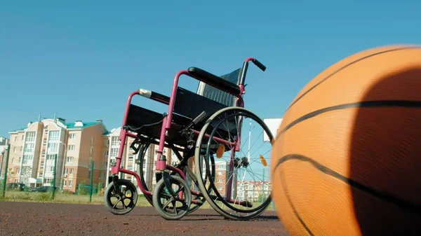 Art des Rollstuhls mit einem Basketballkorb auf einem Sportvolleyballfeld — Stockfoto