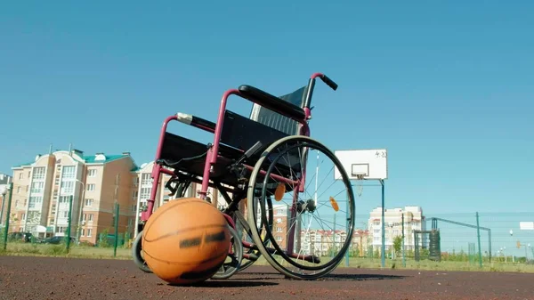 Tipo de cadeira de rodas com uma bola de cesta em um campo de voleibol esportivo — Fotografia de Stock