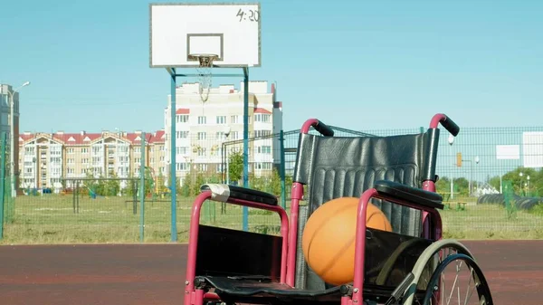 Tipo de cadeira de rodas com uma bola de cesta em um campo de voleibol esportivo — Fotografia de Stock