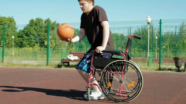 Disabled man plays basketball from his wheelchair, On open air, Make an effort when playing