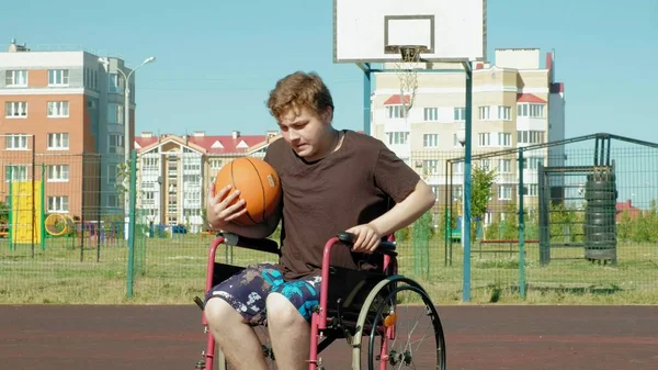 Disabled man plays basketball from his wheelchair, On open air, Make an effort when playing