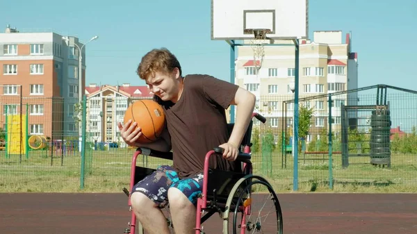 Homem com deficiência joga basquete de sua cadeira de rodas, Ao ar livre, Faça um esforço ao jogar — Fotografia de Stock