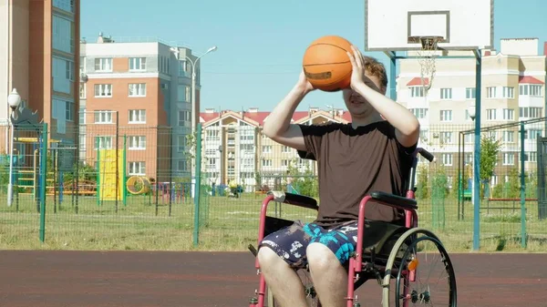 Disabled man plays basketball from his wheelchair, On open air, Make an effort when playing