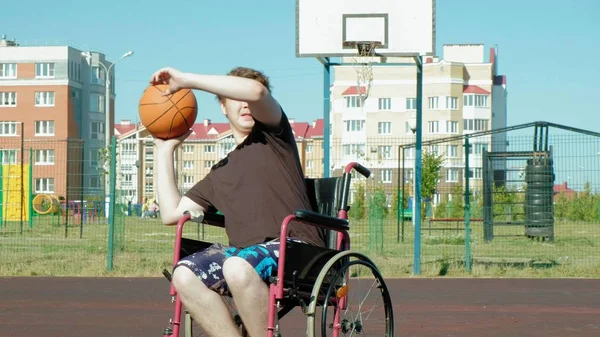Disabled man plays basketball from his wheelchair, On open air, Make an effort when playing