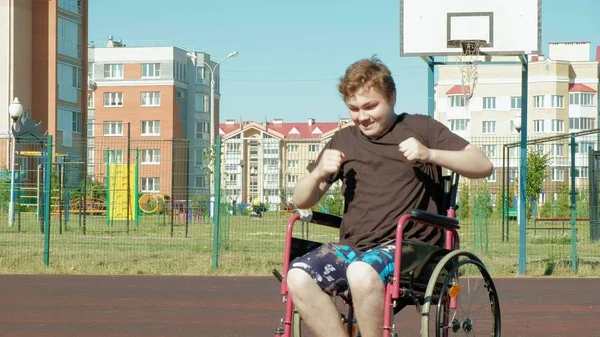 Disabled man plays basketball from his wheelchair, On open air, Make an effort when playing