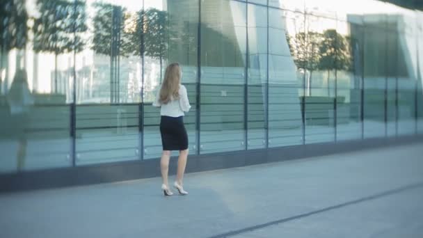 Молодая деловая женщина прогуливается в бизнес-центре городского парка — стоковое видео