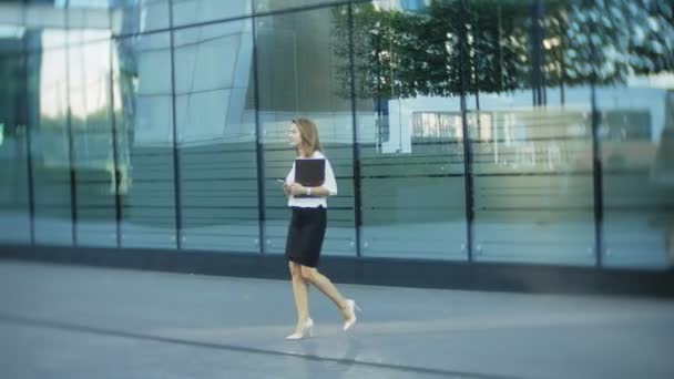 Молодая деловая женщина прогуливается в бизнес-центре городского парка — стоковое видео