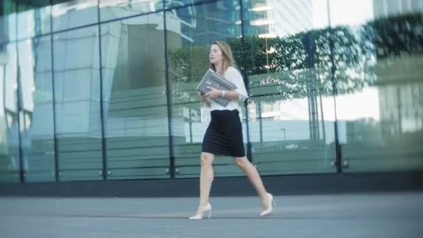 Jonge zakenvrouw is wandelen in het city park business center — Stockvideo