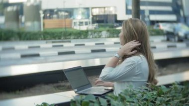 Şehir park iş merkezi içinde laptop üzerinde çalışan genç iş kadını