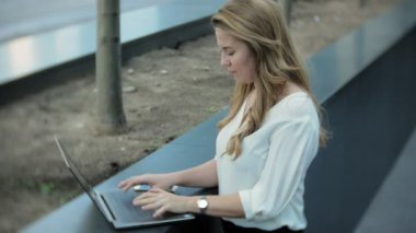 Şehir park iş merkezi içinde laptop üzerinde çalışan genç iş kadını