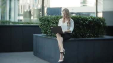 Şehir park iş merkezi içinde laptop üzerinde çalışan genç iş kadını