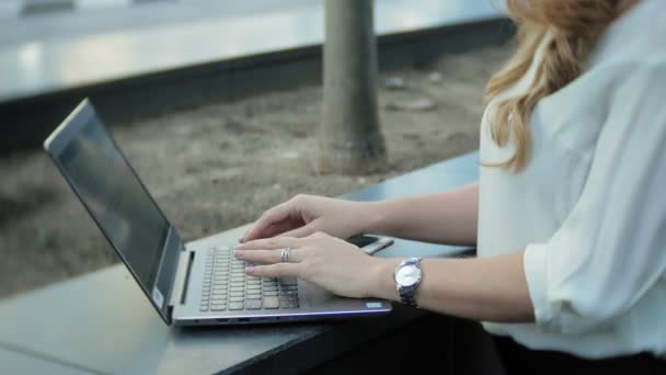 Şehir park iş merkezi içinde laptop üzerinde çalışan genç iş kadını — Stok video