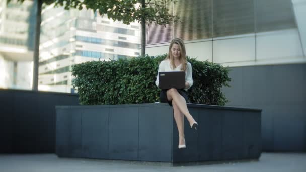 Ung affärskvinna arbetar på laptop i city park Businesscenter — Stockvideo