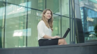 Şehir park iş merkezi içinde laptop üzerinde çalışan genç iş kadını