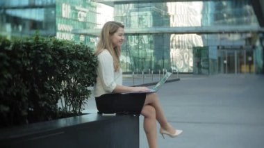 Şehir park iş merkezi içinde laptop üzerinde çalışan genç iş kadını