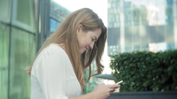 Young businesswoman talking is using smartphone in city park business center — Stock Video