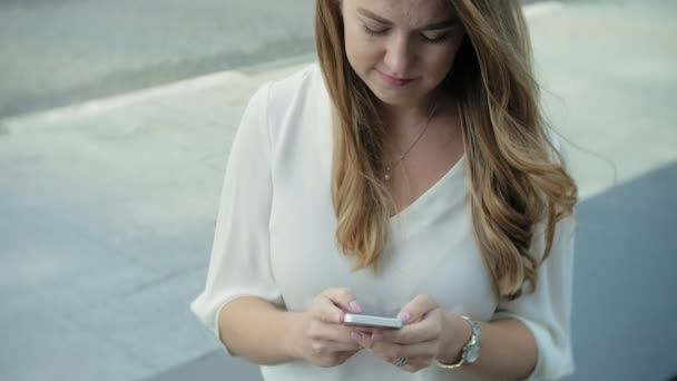 Jovem empresária falando está usando smartphone no centro de negócios do parque da cidade — Vídeo de Stock