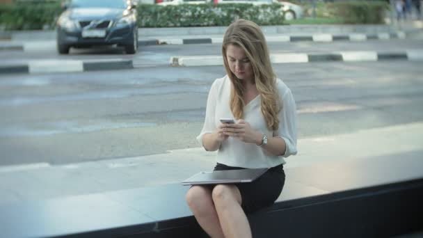 Young businesswoman talking is using smartphone in city park business center — Stock Video