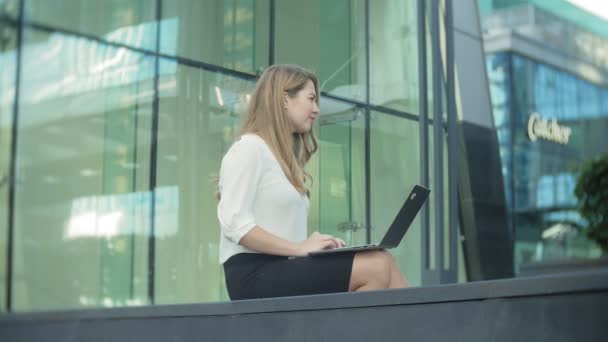 Junge Geschäftsfrau arbeitet am Laptop im City Park Business Center — Stockvideo