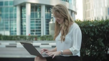 Şehir park iş merkezi içinde laptop üzerinde çalışan genç iş kadını