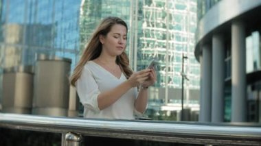 Genç işkadını konuşmak smartphone şehir park iş merkezinde kullanıyor