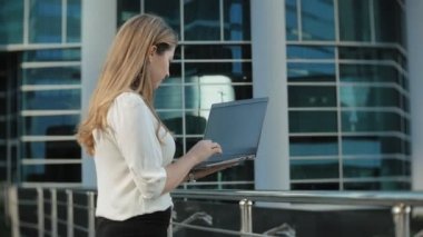 Şehir park iş merkezi içinde laptop üzerinde çalışan genç iş kadını