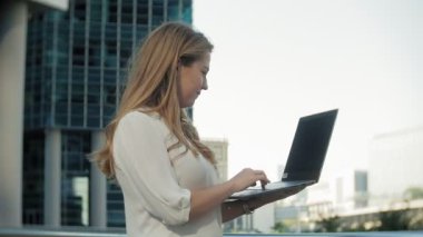 Şehir park iş merkezi içinde laptop üzerinde çalışan genç iş kadını