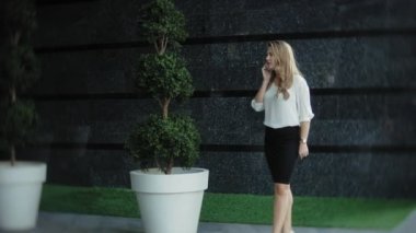 Genç işkadını konuşmak smartphone şehir park iş merkezinde kullanıyor