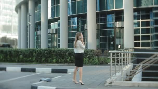 Joven mujer de negocios está paseando en el centro de negocios del parque de la ciudad — Vídeo de stock