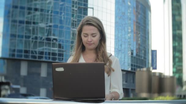 Giovane donna d'affari che lavora su laptop nel centro commerciale del parco cittadino — Video Stock