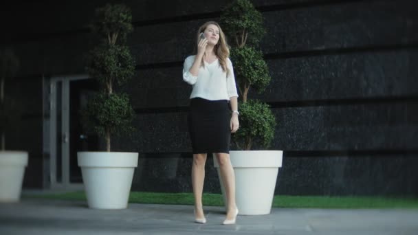 Young businesswoman talking is using smartphone in city park business center — Stock Video