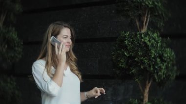 Genç işkadını konuşmak smartphone şehir park iş merkezinde kullanıyor