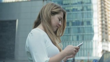 Genç işkadını konuşmak smartphone şehir park iş merkezinde kullanıyor