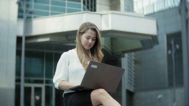 Junge Geschäftsfrau arbeitet am Laptop im City Park Business Center — Stockvideo