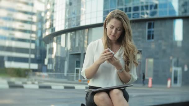 Joven mujer de negocios hablando está utilizando el teléfono inteligente en el centro de negocios del parque de la ciudad — Vídeo de stock