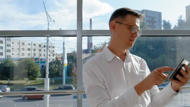 Empresário maduro em uma janela com uma pastilha — Vídeo de Stock